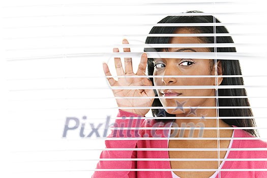 Young black woman looking through horizontal venetian blinds Young black woman looking through horizontal venetian blinds