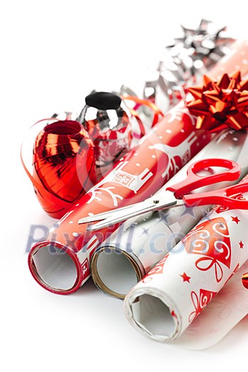 Rolls of Christmas wrapping paper with ribbons, bows and scissors Rolls of Christmas wrapping paper with ribbons, bows and scissors