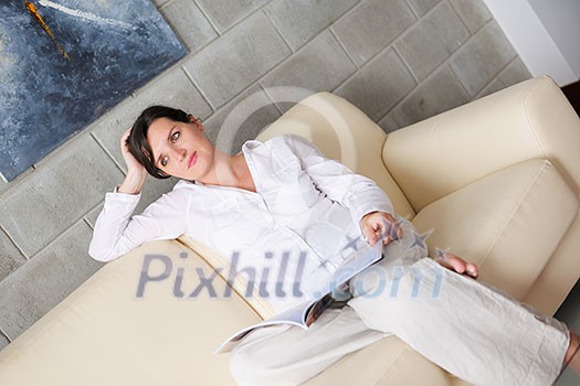 happpy young woman reading magazina at home in comfortabel sofa and bright living room happpy young woman reading magazina at home in comfortabel sofa and bright living room