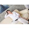 happpy young woman reading magazina at home in comfortabel sofa and bright living room