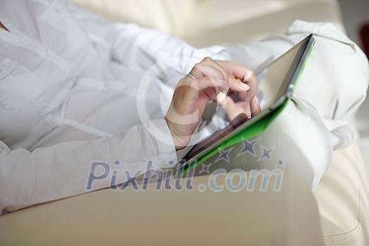Young woman at home relaxing in her lliving room reading a digital tablet PC surf internet and work Young woman at home relaxing in her lliving room reading a digital tablet PC surf internet and work