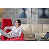 happy young woman relax at home on sofa in bright living room and watching tv