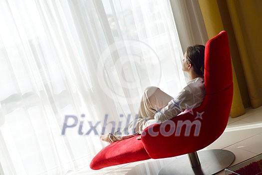 happy young woman relax at home on sofa in bright living room and watching tv happy young woman relax at home on sofa in bright living room and watching tv