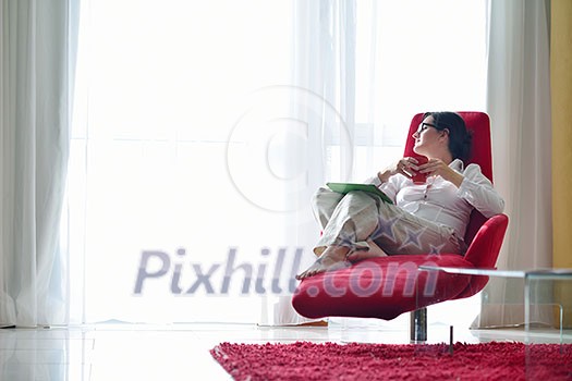 Young woman at home relaxing in her lliving room reading a digital tablet PC surf internet and work Young woman at home relaxing in her lliving room reading a digital tablet PC surf internet and work