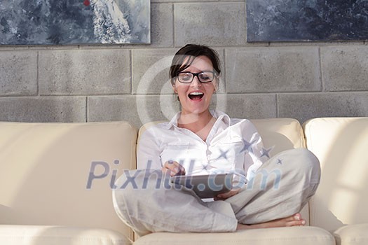 Young woman at home relaxing in her lliving room reading a digital tablet PC surf internet and work Young woman at home relaxing in her lliving room reading a digital tablet PC surf internet and work