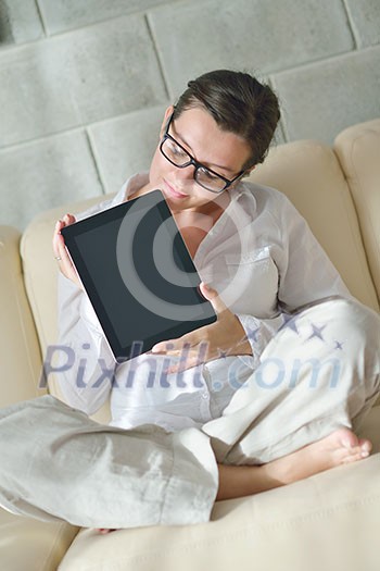 Young woman at home relaxing in her lliving room reading a digital tablet PC surf internet and work Young woman at home relaxing in her lliving room reading a digital tablet PC surf internet and work