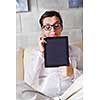 Young woman at home relaxing in her lliving room reading a digital tablet PC surf internet and work