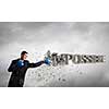 Young businessman in blue boxing gloves breaking impossible word