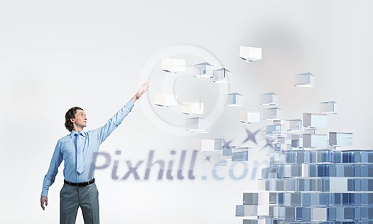 Businessman reaching hand to touch digital cube figure Businessman reaching hand to touch digital cube figure