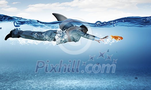 Young businessman with shark flipper swiming under water Young businessman with shark flipper swiming under water