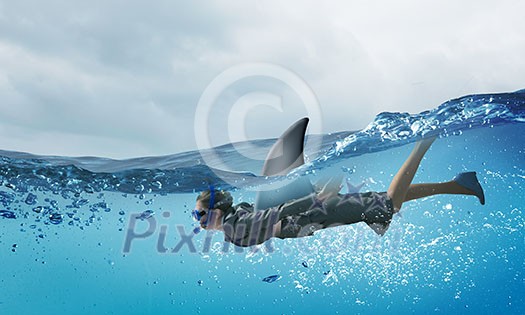 Young businesswoman with shark flipper swiming under water Young businesswoman with shark flipper swiming under water