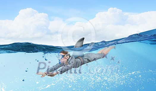 Young businesswoman with shark flipper swiming under water Young businesswoman with shark flipper swiming under water