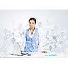 Beautiful young lady at desk working on laptop with social network concept at background