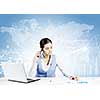 Beautiful young lady at desk talking on mobile phone with social network concept at background