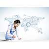 Beautiful young lady at desk working on laptop with social network concept