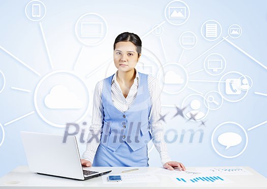 Young businesswoman at desk with laptop and cloud computing concept on background Young businesswoman at desk with laptop and cloud computing concept on background
