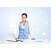 Young businesswoman at desk with laptop and cloud computing concept on background