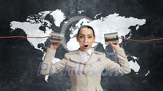 Young pretty businesswoman attaching tin phone to ear Young pretty businesswoman attaching tin phone to ear