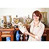 Proud woman holding vase from her collection of antiques
