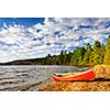 Red canoe on beach at Lake of Two Rivers, Ontario, Canada
