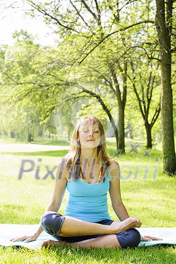 Female fitness instructor in lotus yoga pose outdoor at spring park Female fitness instructor in lotus yoga pose outdoor at spring park