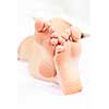 Soles of soft female bare feet crossed in closeup