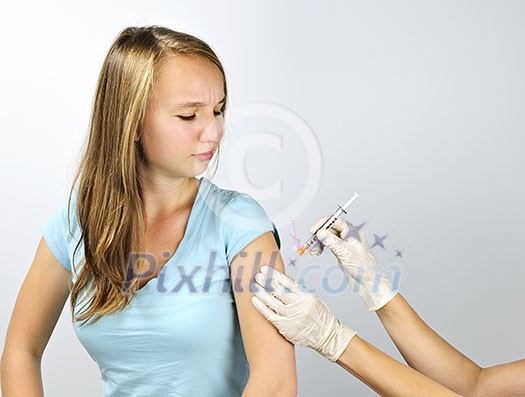 Teenage girl getting flu shot needle vaccination in arm Teenage girl getting flu shot needle vaccination in arm