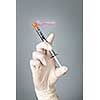 Medical safety syringe held by hand in surgical latex glove