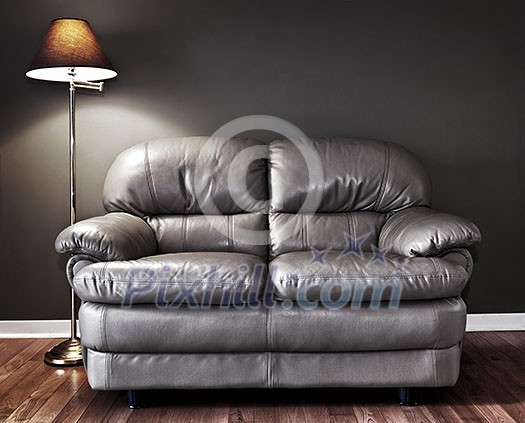 Leather love seat and floor lamp against dark wall Leather love seat and floor lamp against dark wall