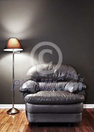 Leather chair and floor lamp against dark wall Leather chair and floor lamp against dark wall