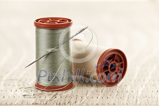 Two spools of thread with needle for sewing Two spools of thread with needle for sewing