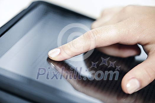 Female hand touching tablet computer screen with finger Female hand touching tablet computer screen with finger