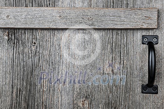 Distressed rustic barn wood door with handle as textured background Distressed rustic barn wood door with handle as textured background