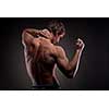 Muscular naked man from back on black