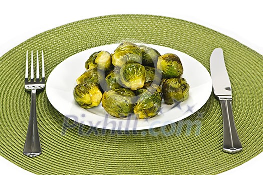 Plate of green brussels sprouts with knife and fork Plate of green brussels sprouts with knife and fork