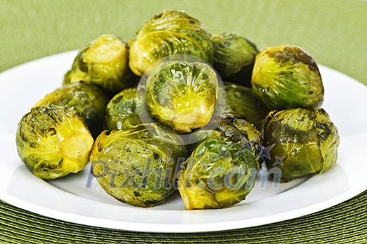 Plate of roasted green brussels sprouts on placemat Plate of roasted green brussels sprouts on placemat