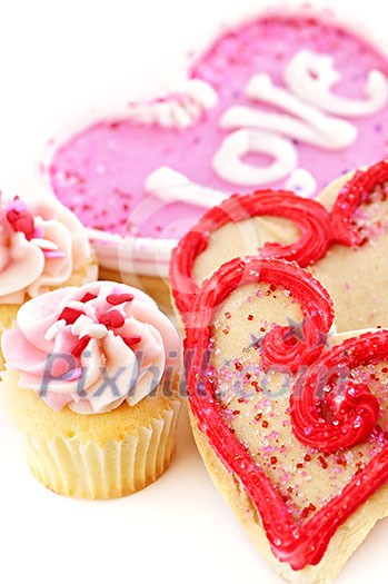 Homemade baked shortbread Valentine cookies and cupcakes with icing on white background Homemade baked shortbread Valentine cookies and cupcakes with icing on white background