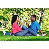 Young romantic couple celebrating with wine in summer park
