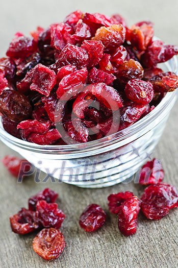 Dried cranberries spilling out of glass bowl Dried cranberries spilling out of glass bowl