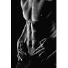 Sexy muscular naked man with water drops on stomach