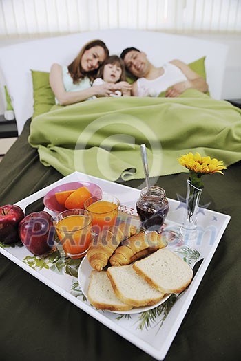 happy young family eat breakfast in bed at morning happy young family eat breakfast in bed at morning