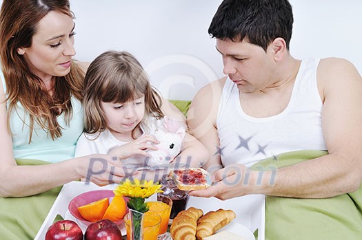 happy young family eat breakfast in bed at morning happy young family eat breakfast in bed at morning