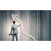 Rear view of businessman fixing wooden graph arrow with drill