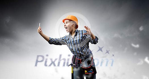 Young emotional woman mechanic screaming in mobile phone Young emotional woman mechanic screaming in mobile phone