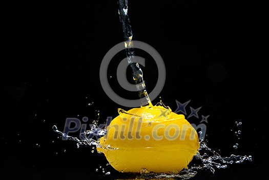 Fresh lemon and water splash isolated on black Fresh lemon and water splash isolated on black