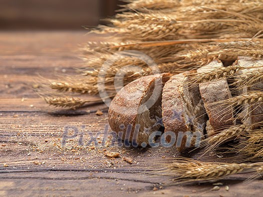 Bread and wheat on wooden table, shallow DOF, raw image Bread and wheat on wooden table, shallow DOF, raw image