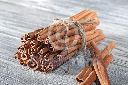 Cinnamon sticks isolated on white wooden background Cinnamon sticks isolated on white wooden background