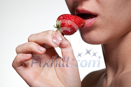 Young woman biting strawberry isolated on white Young woman biting strawberry isolated on white