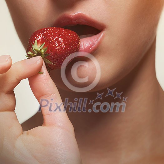 Young woman biting strawberry isolated on white Young woman biting strawberry isolated on white