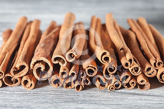Cinnamon sticks isolated on white wooden background Cinnamon sticks isolated on white wooden background